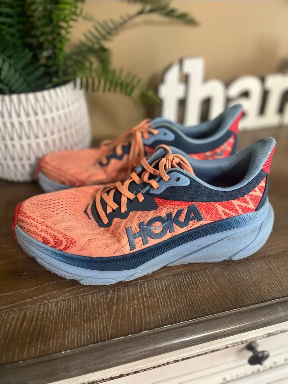 HOKA Women's Challenger ATR 7 sneakers feature a vibrant papaya orange mesh